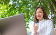 © Farknot Architect - Portrait image of a woman drink coffee while working on laptop computer in the outdoors