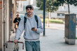 © carballo - student with mobile phone on the street walking with the vintage bicycle