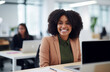 © Minimal Blue - Smiling Businesswoman In A Modern Office Setting With Colleagues Working In The Background And Laptops On Desks