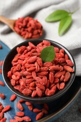 Wall Mural - Dried goji berries in bowl on table, closeup