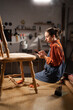 © Andrii Lysenko - DIY handmade. Woman carpenter wearing apron using mobile phone for chatting in carpentry workshop, repairing old wooden furniture