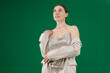 © Oleksandra - young woman dances on a green background chromakey woman in a beautiful Silver dress and jackets smiles opens the jacket shows beautiful teeth hair well-groomed. dear girl