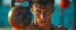 © Liffer - Focused young man working out with kettlebell, intense fitness training in outdoor gym setting with blurred background.