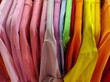 © Andrii - Photo of colored clothes on hangers. Supermarket with t-shirts