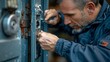 © INT888 - A man is using a screwdriver to fix a door lock.  He is concentrated on his work.  The image is close-up and in focus.