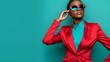 © Nataliia_Trushchenko - A woman in a red suit and green shirt poses for a photo. She is wearing sunglasses and has her hand on her hip. The image has a bold and confident mood, with the woman standing tall