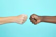 © Ольга Лукьяненко - Woman and African American woman making fist bump on light blue background, closeup