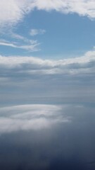 Wall Mural - aerial view. blue sky sun and fog over calm sea. the drone flies over foggy and fluffy clouds. abstr