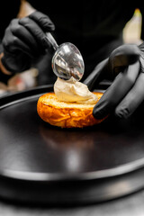 Wall Mural - Close-up of a chef’s hands in black gloves plating a gourmet dish, with focus on the food