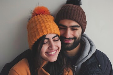 Canvas Print - Portrait of a joyful indian couple in their 20s donning a warm wool beanie in front of minimalist or empty room background