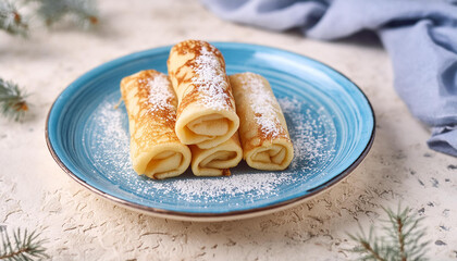 Wall Mural - Rolled pancakes powdered with sugar on blue ceramic dish. Tasty food. Delicious breakfast.