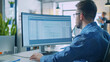 © VK Studio - An office worker intensely examining a spreadsheet on a widescreen monitor, in a bright, modern office environment.