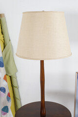 Vintage 1960s table floor lamp. Mid-century modern walnut furniture. Home interior photograph with rolls of fabric.