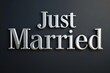 © Jullia - Elegant 'Just Married' Sign in Silver Lettering on a Dark Background for Wedding Celebrations
