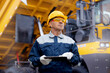 © Parilov - Coal mining worker use tablet computer on background big yellow truck