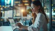 © Plaifah - A businesswoman analyzing sales data graphs on a laptop in a modern office.
