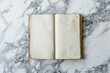 © Archibalttttt - A minimalist composition featuring an open blank notebook resting on a marble surface