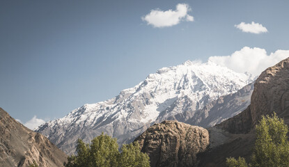 Wall Mural - Panorama of mountain range of rocks with snow and glaciers in Pamir in Tajikistan mountains in cloudy weather, minimalistic landscape of high mountains for background