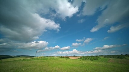 Wall Mural - timelapse of summer clouds over a green meadow