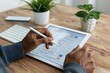 © Yuliia - person filling out an online survey form on a digital tablet at a wooden desk