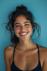 Wall Mural - Caucasian female athlete smiling with confidence on blue background.