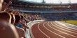 © lacindex - Excited crowd cheering at an olympic track and field event in paris, sunlight shining over the stadium