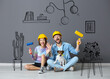 © Pixel-Shot - Young couple with painter's rollers and cute dog in drawn interior of their new home