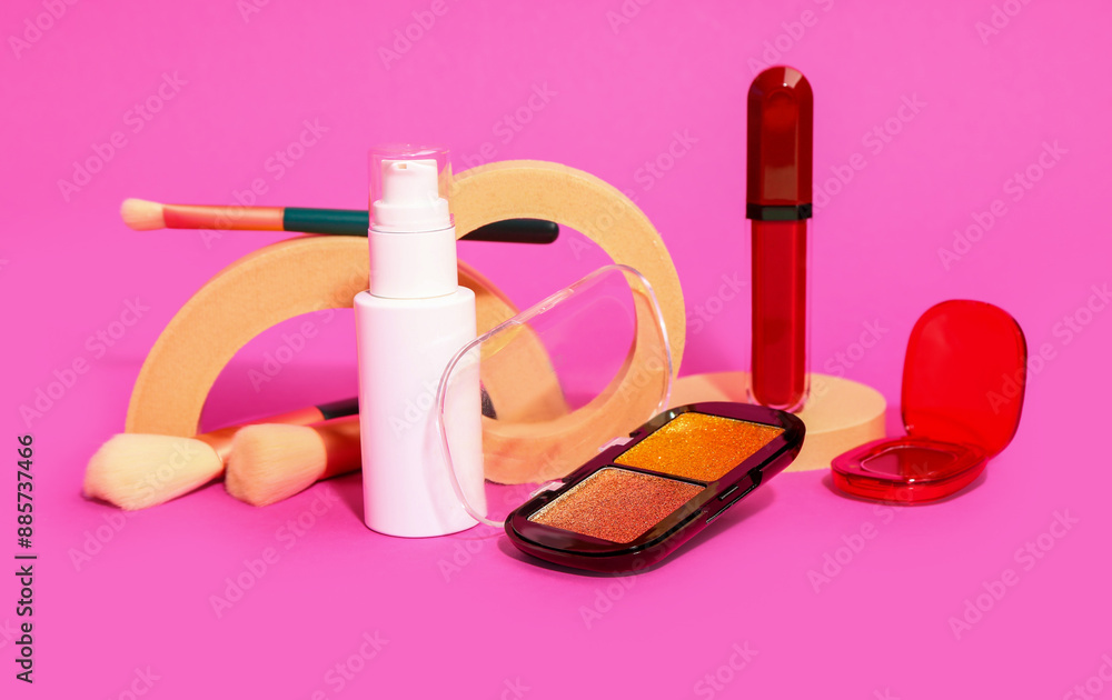 Different makeup cosmetics on pink background