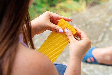 Woman makes a decorative candle from natural beeswax, hobby and home business of a beekeeper farmer