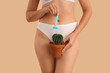 © Pixel-Shot - Beautiful young woman with razor and cactus on beige background, closeup