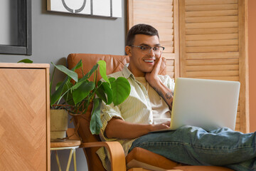 Canvas Print - Male author with laptop in armchair at home