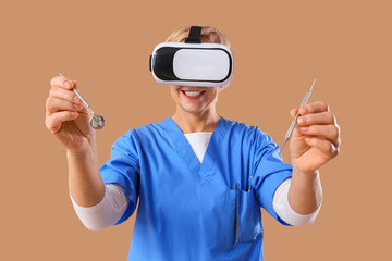 Canvas Print - Mature female dentist in VR glasses with tools on brown background