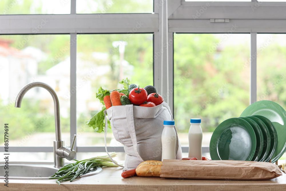 Shopping bag with products near sink in kitchen