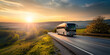 © Andres Mejia - Tour bus driving on country road during golden hour sunset