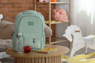 Wall Mural - Backpack with apple and water bottle on table in children's room