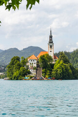 Panoramic view from Lake Bled, beauty heritage in Slovenia. Island with church and castle in the background create a dream setting. View from Ojstrica and Mala Osojnica with the heart-shaped bench.