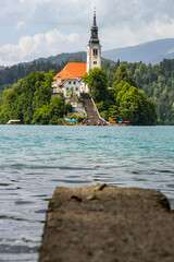 Panoramic view from Lake Bled, beauty heritage in Slovenia. Island with church and castle in the background create a dream setting. View from Ojstrica and Mala Osojnica with the heart-shaped bench.