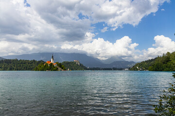 Wall Mural - Panoramic view from Lake Bled, beauty heritage in Slovenia. Island with church and castle in the background create a dream setting. View from Ojstrica and Mala Osojnica with the heart-shaped bench.