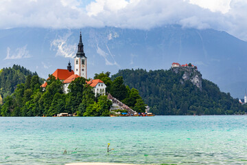 Wall Mural - Panoramic view from Lake Bled, beauty heritage in Slovenia. Island with church and castle in the background create a dream setting. View from Ojstrica and Mala Osojnica with the heart-shaped bench.