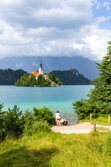 Wall Mural - Panoramic view from Lake Bled, beauty heritage in Slovenia. Island with church and castle in the background create a dream setting. View from Ojstrica and Mala Osojnica with the heart-shaped bench.