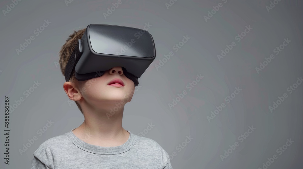 Young boy immersed in virtual reality experience wearing headset on ...