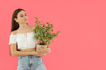 Wall Mural - An attractive young girl is holding a flower pot