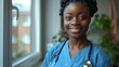 © ifoto - portrait of smiling young black nurse with stethoscope in blue scrubs