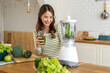 © Art_Photo - Portrait of beauty healthy asian woman making green vegetables detox cleanse and green fruit smoothie with blender.young girl drinking glass of smoothie, fiber, chlorophyll in kitchen.Diet, healthy