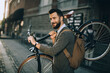 © Geber86 - Stylish young man carrying bicycle on urban street