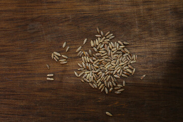 Wall Mural - roasted rye grains on a wooden table, food background