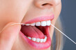 © Yevhen - Teeths Flossing. Oral hygiene and health care. Smiling women use dental floss white healthy teeth. Dental flush - woman flossing teeth. Dental floss. Taking care of teeth. Healthy teeth concept