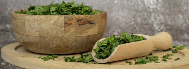 Wooden bowl with green dry parsley. Vegetarian bio organic salad herb healthy eating. Home garden immunity-boosting herbs. Seasonal harvest cottagecore