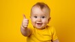 © sorin - Happy toddler giving a thumbs up on bright yellow background, expressing positivity and approval