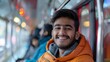 © movinglines.studio - Young Indian Man in Orange Jacket Smiling on a Busy Train Ride